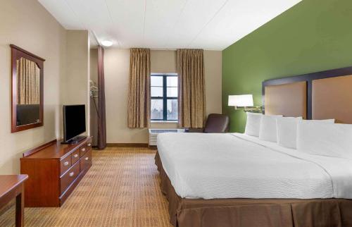 a hotel room with a large bed and a television at Extended Stay America Select Suites - Chicago - Lisle in Lisle