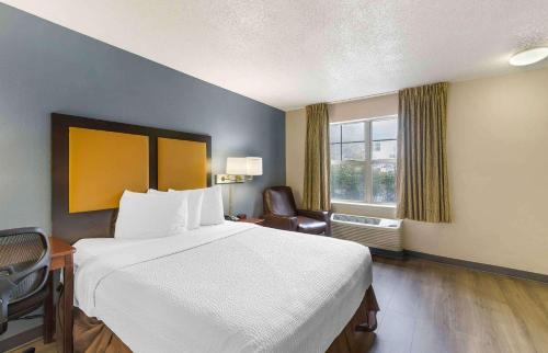 a hotel room with a large bed and a chair at Extended Stay America Suites - Memphis - Germantown West in Memphis