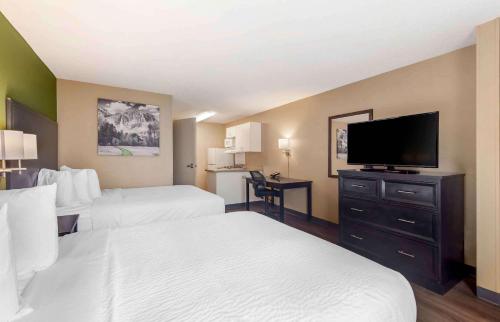 a hotel room with two beds and a flat screen tv at Extended Stay America Suites - Memphis - Germantown West in Memphis