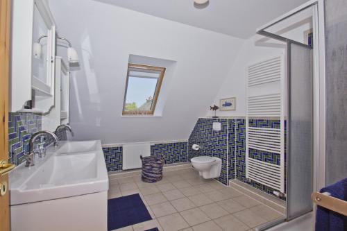 uma casa de banho com um WC e um lavatório em Ferienhaus Hideaway Haus - Terrasse, Garten, strandnah em Neuendorf