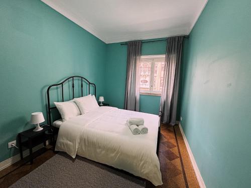 een blauwe slaapkamer met een bed met een witte deken bij Charme Lisboeta in Lissabon