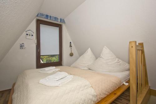 a bedroom with a bed with towels on it at Finnhaus Nr 52 Haus - strandnah, Terrasse, Garten in Gager