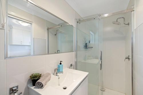 ein weißes Badezimmer mit Waschbecken und Dusche in der Unterkunft The Seascape Shack in Cowes