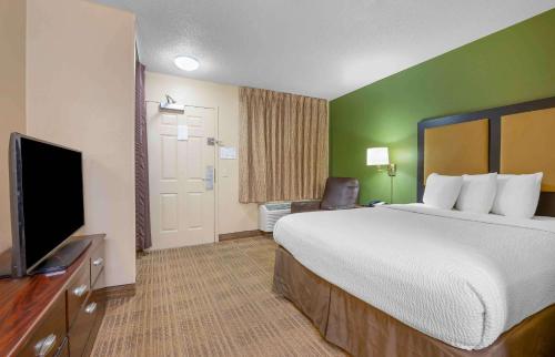 a hotel room with a bed and a flat screen tv at Extended Stay America Select Suites - Tampa - Brandon in Brandon