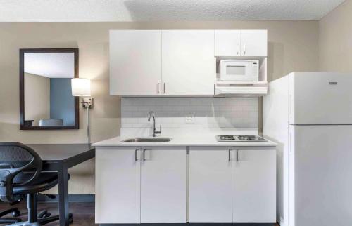 uma cozinha com armários brancos, um lavatório e um micro-ondas em Extended Stay America Premier Suites - Union City - Dyer St em Union City