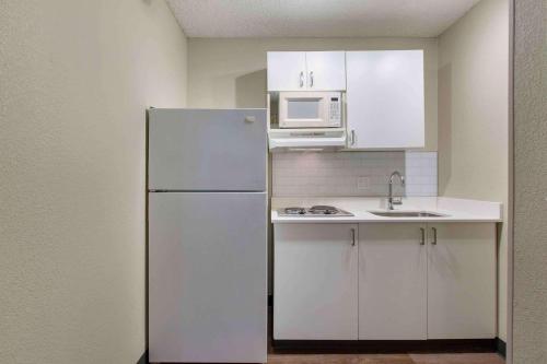 a white kitchen with a refrigerator and a microwave at Extended Stay America Premier Suites - Union City - Dyer St in Union City