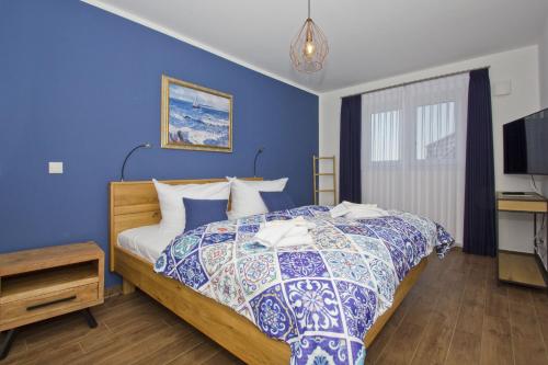 a bedroom with a bed with a blue wall at Ferienhaus Luna Haus - Terrasse, Garten, Sauna in Breege
