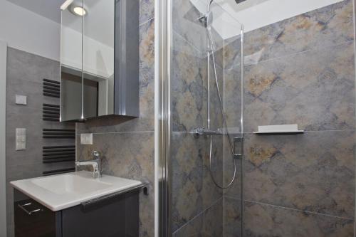 W łazience znajduje się umywalka i prysznic. w obiekcie Ferienhaus Luna Haus - Terrasse, Garten, Sauna w mieście Breege
