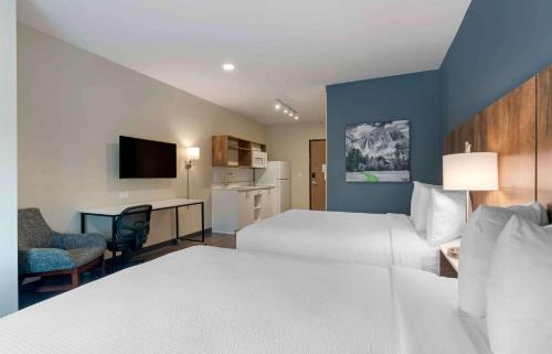 a large hotel room with two beds and a desk at Extended Stay America Premier Suites - Daytona Beach - Ormond Beach in Ormond Beach