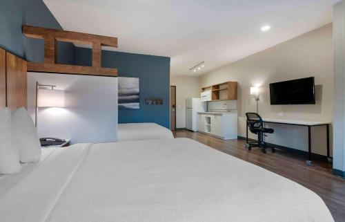a hotel room with a large bed and a desk at Extended Stay America Premier Suites - Daytona Beach - Ormond Beach in Ormond Beach