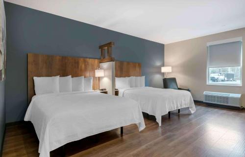 a hotel room with two beds and a window at Extended Stay America Premier Suites - Daytona Beach - Ormond Beach in Ormond Beach
