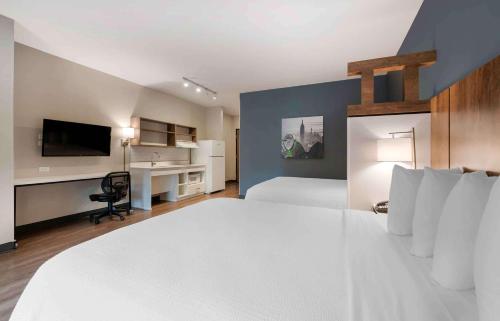 a bedroom with a large white bed and a desk at Extended Stay America Premier Suites - Daytona Beach - Ormond Beach in Ormond Beach