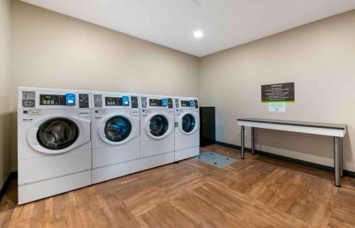 a laundry room with three washing machines and a counter at Extended Stay America Premier Suites - Daytona Beach - Ormond Beach in Ormond Beach