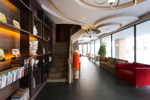 a library with a red couch and bookshelves at 麗馨商旅七賢館 in Kaohsiung