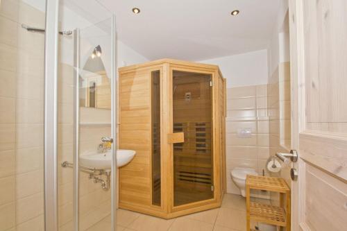 a bathroom with a shower and a toilet and a sink at Ferienhaus Wellenläufer Haus - Sauna, Terrasse, Garten in Glowe