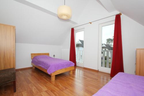 a bedroom with a purple bed and a window at Ferienhaus Wellenläufer Haus - Sauna, Terrasse, Garten in Glowe