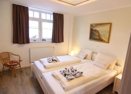 ein Hotelzimmer mit 2 Betten und einem Fenster in der Unterkunft Ferienwohnung Lukas Bockelmann´s Hof (ebenerdig) in Westerland