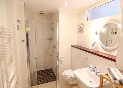 ein Bad mit einer Dusche, einem WC und einem Waschbecken in der Unterkunft Ferienwohnung Lukas Bockelmann´s Hof (ebenerdig) in Westerland
