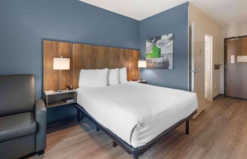 a bedroom with a large bed and a chair at Extended Stay America Suites - Huntsville - Madison in Madison