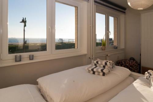 ein Schlafzimmer mit zwei Betten und zwei Fenstern in der Unterkunft Odde Blick in Hörnum