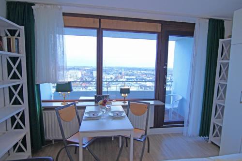 ラントゥムにあるFerienwohnung Binnenkikerのテーブルと椅子、大きな窓が備わる客室です。