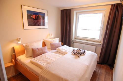 um quarto com uma cama com um urso de peluche em Ferienwohnung Austernfischerin em Westerland