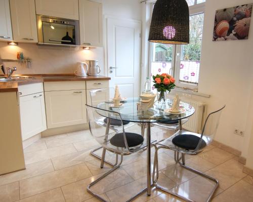 a kitchen with a glass table and two chairs at Ferienwohnung Lena Bockelmann´s Hof (ebenerdig) in Westerland (Sylt)