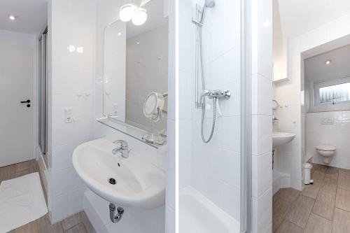 ein weißes Badezimmer mit Dusche und Waschbecken in der Unterkunft Sylt Liebt Dich 3 in Westerland