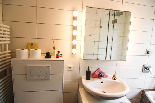 ein Bad mit einem Waschbecken und einem Spiegel in der Unterkunft Ferienwohnung Blaue Huis Erdgeschoß in Wenningstedt-Braderup
