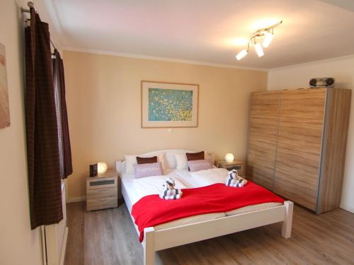 un dormitorio con dos animales de peluche sentados en una cama en Ferienwohnung Jonas Bockelmann´s Hof, en Westerland