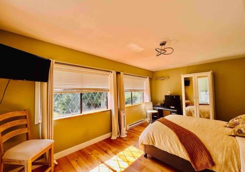 a bedroom with yellow walls and a bed and a window at Oceanside Manor - Golf Course View in Qualicum Beach