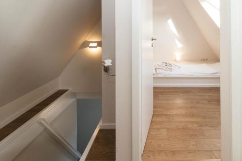 a small attic room with a bed and a stairway at Haus Düne 9 in Hörnum