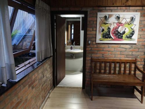 La salle de bains est pourvue de toilettes, d'un banc et d'un lavabo. dans l'établissement Casa da Lagoa - Gasthaus Pomerode, à Pomerode