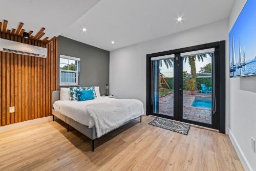 1 dormitorio con 1 cama y puerta corredera de cristal en Oasis with Pool Spa Games 5BR L21, en Miami Gardens