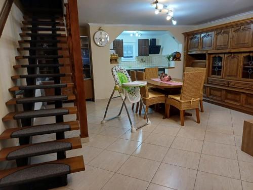 a kitchen and dining room with a spiral staircase at Casa Potcovarului in Drăguş