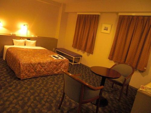 une chambre d'hôtel avec un lit et une table dans l'établissement Main Hotel - Vacation STAY 82551, à Miyakonojō