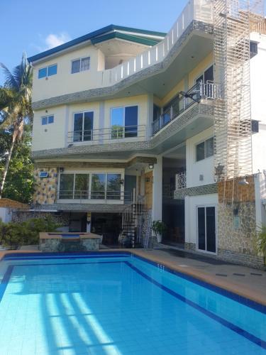 a house with a swimming pool in front of a house at Elicon Suites in Tagbilaran City