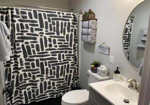 a bathroom with a black and white shower curtain at Modern 2BR Aparment near NC ZOO w Parking in Asheboro