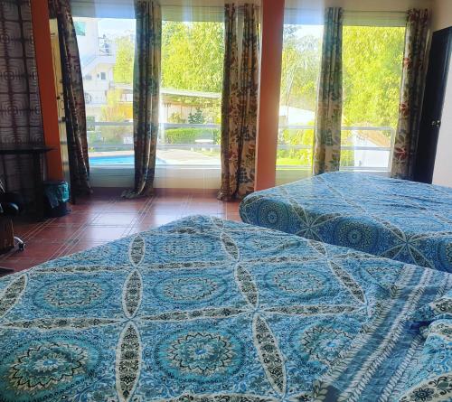 two beds in a room with a large window at Elicon Suites in Tagbilaran City