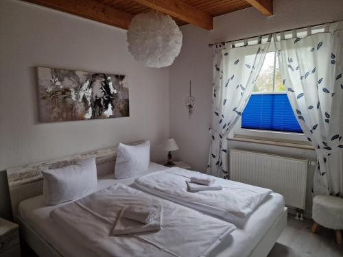 a bedroom with a white bed and a window at Inselsonne Haus Inge - Fewo Inge in Breege in Breege