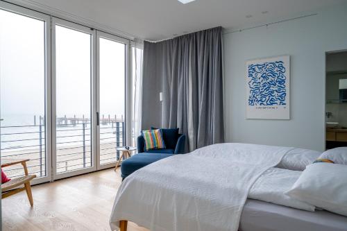 ein Schlafzimmer mit einem großen Bett und einem Balkon in der Unterkunft Strandhaus in Wyk auf Föhr