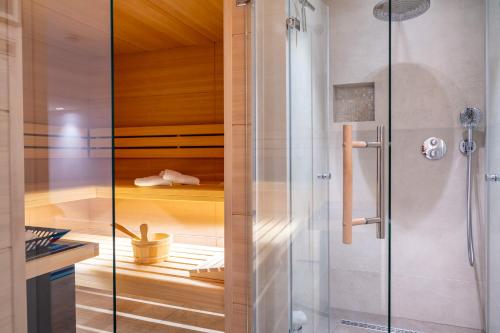 La salle de bains est pourvue d'une douche avec une porte en verre. dans l'établissement Strandhaus, à Wyk auf Föhr