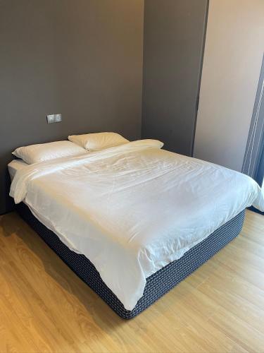 an unmade bed in a bedroom with a wooden floor at Penang Amazing SeaView Private Lift 梹城富人区绝美海景公寓私人电梯 in Tanjong Tokong
