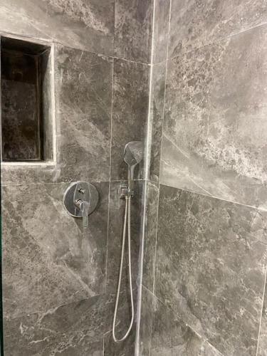 a shower with a hose in a bathroom at Luxueux Appart à 5 min aéroport mohamed 5 in Nouaceur