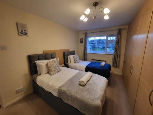 a bedroom with two beds and a window at Lovely apartment with free parking & Wi-Fi in Birmingham
