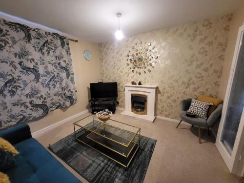 sala de estar con sofá azul y chimenea en Lovely apartment with free parking & Wi-Fi en Birmingham