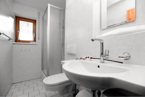 a white bathroom with a sink and a toilet at Appartementhaus "Susanne", Wohnung Seehund in Wustrow