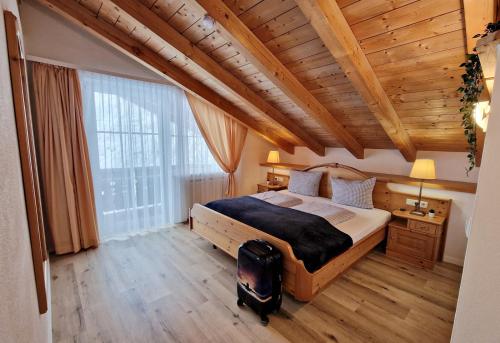 1 dormitorio con cama grande y ventana grande en HoFer am Zeitberg Ferienwohnung Sonneck en Bad Kohlgrub