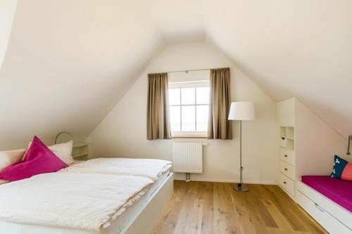 a attic bedroom with a bed and a window at Haus Wiesenweite in Born
