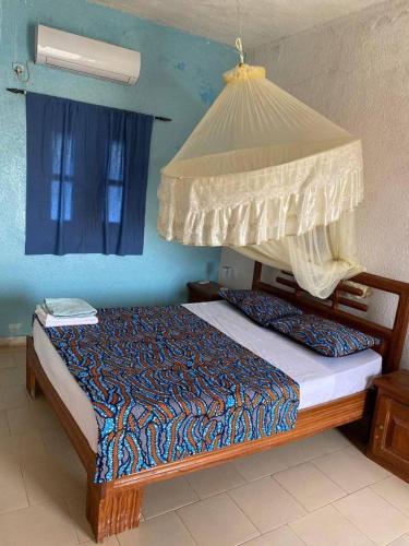 - une chambre avec un lit à baldaquin dans l'établissement Hotel evasion peche, à Fimela